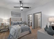 Thumbnail 18 of 21 - 3-Bedroom Apartments in Chattanooga, TN - Populus Waterside - Carpeted Bedroom with Large Bed, Nightstands, Lamps, Private Bathroom, Spacious Closet, and Ceiling Fan.
