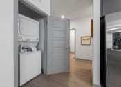 Thumbnail 10 of 21 - a small laundry room with a washer and dryer and a door to a