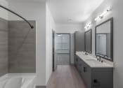 Thumbnail 16 of 21 - a bathroom with a shower and a sink and a mirror