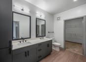 Thumbnail 14 of 21 - a black and white bathroom with two sinks and a toilet