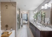 Thumbnail 11 of 38 - a bathroom with a shower and a sink and a mirror
