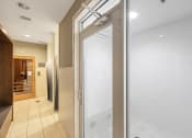Thumbnail 27 of 38 - a glass shower door in a bathroom with a tiled floor