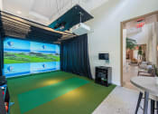Thumbnail 32 of 38 - a game room with a golf simulator and a green carpet