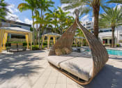 Thumbnail 21 of 38 - a hanging hammock in a pool area at a resort