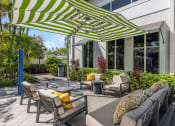 Thumbnail 20 of 38 - a patio with chairs and umbrellas in front of a building