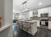 Thumbnail 24 of 45 - a kitchen and living room with an island and stools