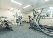 Thumbnail 10 of 37 - A gym with a variety of equipment including a treadmill, stationary bike, and weight bench.
