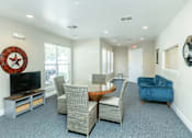 Thumbnail 9 of 37 - A living room with a TV, chairs, and a clock on the wall.