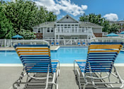 Thumbnail 5 of 37 - Two blue and yellow chairs are in front of a pool.