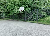 Thumbnail 31 of 37 - A basketball hoop stands in the middle of an outdoor court.