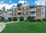 Thumbnail 34 of 37 - Apartment building with a green lawn in front.