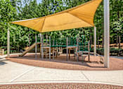Thumbnail 30 of 34 - A playground with a yellow canopy and a slide.