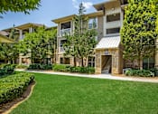 Thumbnail 32 of 34 - Apartment complex with a green lawn in front.