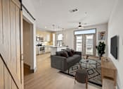 Thumbnail 7 of 43 - A modern living room with a grey couch and a glass coffee table.