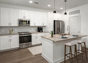 Thumbnail 13 of 50 - a large kitchen with white cabinets and stainless steel appliances