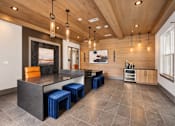 Thumbnail 11 of 29 - A modern kitchen with a wooden ceiling and a large island with blue stools.