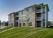 Thumbnail 1 of 49 - A large apartment building with a tree in front of it.