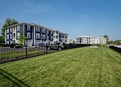 Thumbnail 45 of 49 - A grassy area in front of apartment buildings.