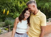 Thumbnail 26 of 28 - A man and a woman are standing close together on a wooden deck.