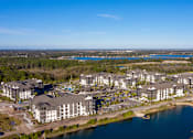 Thumbnail 28 of 29 - A large resort with a body of water in front of it.
