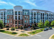 Thumbnail 1 of 53 - A large multi-story building with a mix of brick and glass windows.