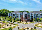 Thumbnail 53 of 53 - A large, modern building with a parking lot in front.