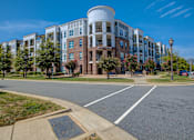 Thumbnail 51 of 53 - A large building with a round tower is surrounded by trees and has a clear blue sky above.