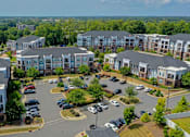 Thumbnail 52 of 53 - A bird's eye view of a parking lot surrounded by apartment buildings.
