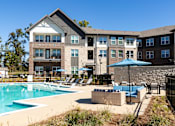 Thumbnail 32 of 45 - A large building with a pool in front of it.