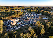 Thumbnail 42 of 45 - A bird's eye view of a resort with a swimming pool and surrounded by trees.