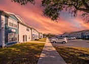 Thumbnail 11 of 15 - A residential area with houses and parked cars.
