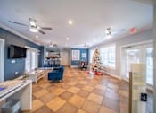 Thumbnail 5 of 15 - A living room with a Christmas tree and a checkered floor.