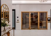 Thumbnail 16 of 34 - A glass door with a gold frame is the main focus of the image.