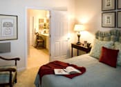 Thumbnail 13 of 23 - A bedroom with a bed, a chair, a desk, and pictures on the wall.