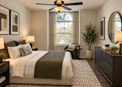 Thumbnail 12 of 20 - A bedroom with a large bed and a ceiling fan.