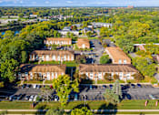Thumbnail 18 of 18 - A large building complex with a parking lot in front.
