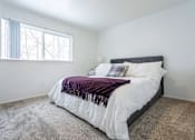 Thumbnail 6 of 18 - A bedroom with a large bed and a window.