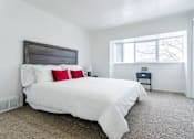 Thumbnail 7 of 18 - A bedroom with a large bed and a small nightstand.