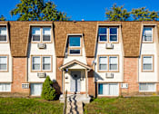 Thumbnail 14 of 18 - A row of townhouses with a clear blue sky above.
