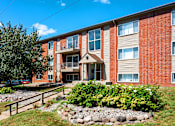 Thumbnail 1 of 18 - A red brick building with a landscaped front yard.