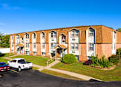Thumbnail 15 of 18 - A white pickup truck is parked in front of a red car and a brick apartment building.