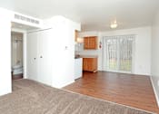 Thumbnail 10 of 18 - A white room with a brown rug and a wooden counter.