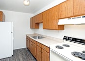 Thumbnail 11 of 18 - A kitchen with a white fridge and a white stove.