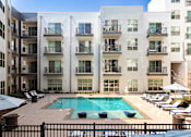 Thumbnail 1 of 57 - a pool is in front of an apartment building