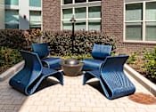 Thumbnail 52 of 57 - an outdoor seating area with blue chairs and a fire pit