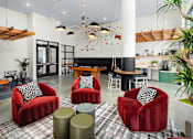 Thumbnail 38 of 57 - a living room with red chairs and a table