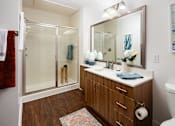 Thumbnail 14 of 57 - a bathroom with a shower and a sink and a mirror