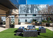 Thumbnail 21 of 32 - A modern outdoor seating area with a large screen displaying an image of a tree.