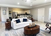 Thumbnail 18 of 23 - A modern living room with a white couch and a wooden coffee table.