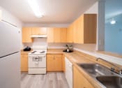 Thumbnail 19 of 43 - A kitchen with wooden cabinets and a white refrigerator.